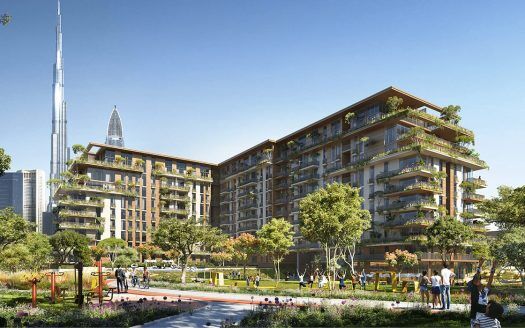 Complexe résidentiel verdoyant et luxuriant avec des bâtiments modernes à plusieurs étages, des jardins paysagers rappelant un parc central et des personnes pratiquant des activités de plein air par une journée ensoleillée, avec un grand gratte-ciel visible en arrière-plan.