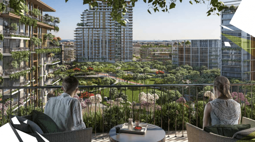 Two people seated on a balcony overlooking Central Park, lush gardens and skyscrapers. The balcony features modern seating and a small table.