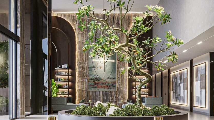 Un hall d'entrée luxueux comprenant un coin salon circulaire central avec des tabourets moelleux, un grand arbre comme pièce maîtresse, entouré d'une verdure luxuriante, sous un grand luminaire circulaire inspiré du style Oxford 212, avec