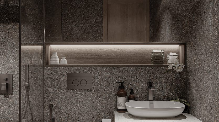 Une salle de bains moderne avec des murs gris foncé texturés, une vanité en bois avec un lavabo blanc Oxford 212, des armoires à miroir et des toilettes murales. Il y a une cloison de douche en verre à gauche.