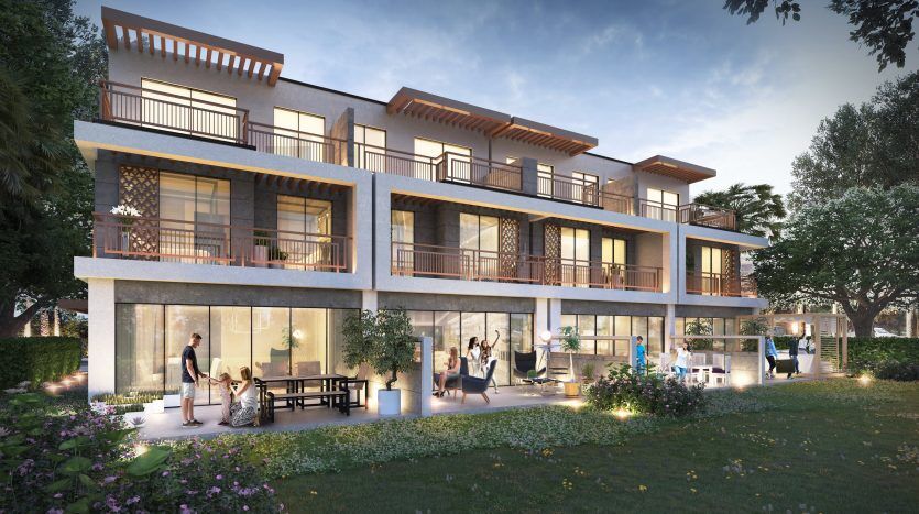 Immeuble résidentiel moderne de trois étages à Dubaï au crépuscule, doté de grandes fenêtres en verre, de balcons et de résidents actifs profitant de diverses activités intérieures et extérieures. Une verdure luxuriante entoure la propriété.