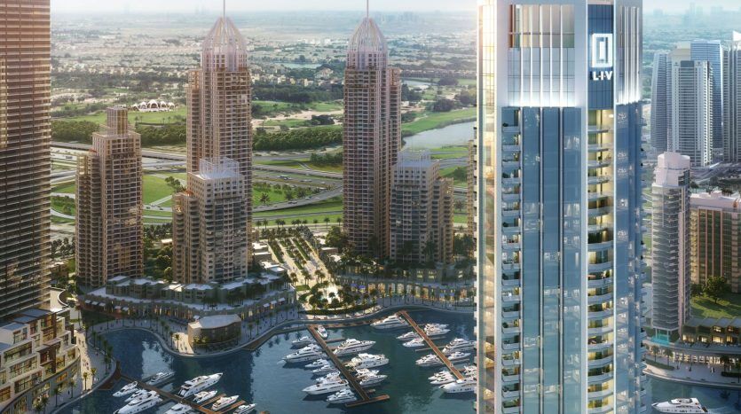 Une vue panoramique d'un complexe luxueux en bord de mer avec des immeubles de grande hauteur, une marina remplie de yachts et un environnement paysager sous un ciel bleu clair, mettant en valeur des immeubles d'appartements de premier plan à Dubaï.
