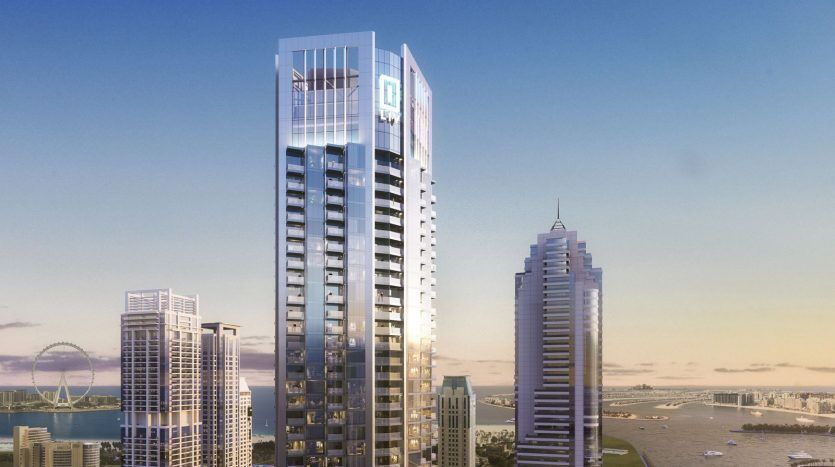 Vue aérienne d'un gratte-ciel moderne à Dubaï au lever du soleil, avec le paysage urbain et le littoral en arrière-plan sous un ciel bleu clair. Des bâtiments à proximité et une grande roue sont également visibles.