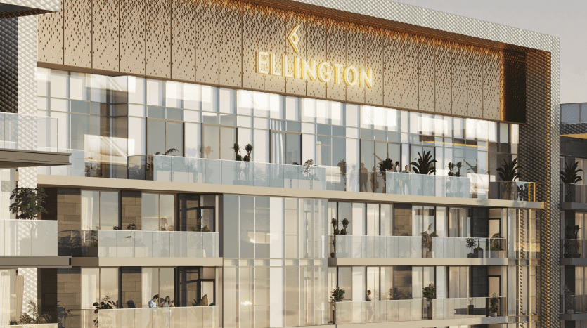 Vue extérieure du bâtiment moderne Ellington à Dubaï au coucher du soleil, avec une façade élégante avec balcons, balustrades en verre et plantations luxuriantes. La signalétique du bâtiment est mise en évidence.