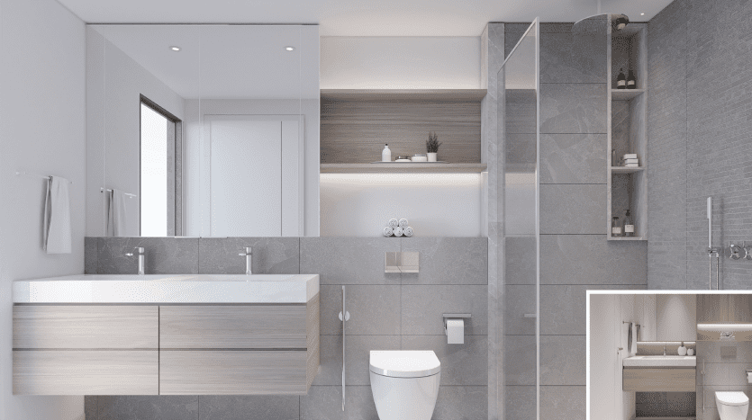 Une salle de bains moderne dans cet appartement de Dubaï comprend une vasque flottante avec deux lavabos, un grand miroir, une cabine de douche en verre et du carrelage gris. Une petite image en insert montre une autre vue avec les toilettes et