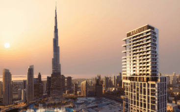 Vue du coucher de soleil sur l'horizon de Dubaï avec un grand gratte-ciel et des bâtiments modernes baignés de lumière dorée.
