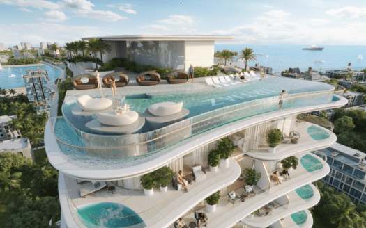 Un grattacielo di lusso dispone di un'ampia piscina a sfioro sul tetto con moderne sedie a sdraio e aree prendisole. Le persone si rilassano a bordo piscina, che si affaccia su una pittoresca cittadina costiera con vegetazione lussureggiante, edifici e uno yacht sull'acqua.