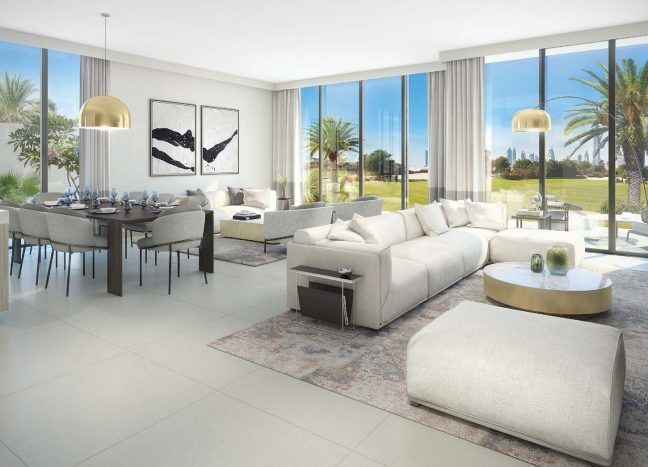Un salon moderne dans les collines de Dubaï avec de grandes fenêtres donnant sur les palmiers. Il dispose d'un canapé sectionnel, d'un coin repas et d'une décoration élégante dans des tons neutres.