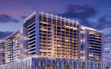 Un immeuble moderne de grande hauteur illuminé au crépuscule à Dubaï, doté de fenêtres en verre réfléchissantes et de poutres horizontales sur sa façade, sur un ciel vibrant avec des nuages.