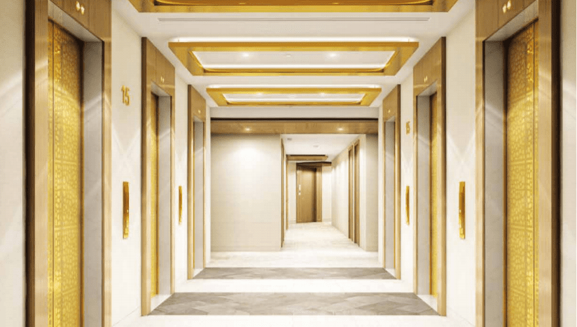 Un couloir d'hôtel luxueux sur Imperial Avenue présentant un design épuré et moderne avec des accents dorés, des luminaires élégants et des portes numérotées.