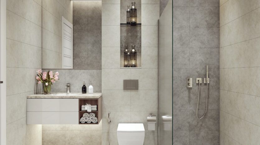 Une salle de bain moderne au Panthéon Elysée comprenant une douche à l'italienne avec une cloison en verre, un meuble flottant avec lavabo, des toilettes suspendues et des murs et sol carrelés de couleur neutre. Les fleurs roses ajoutent un