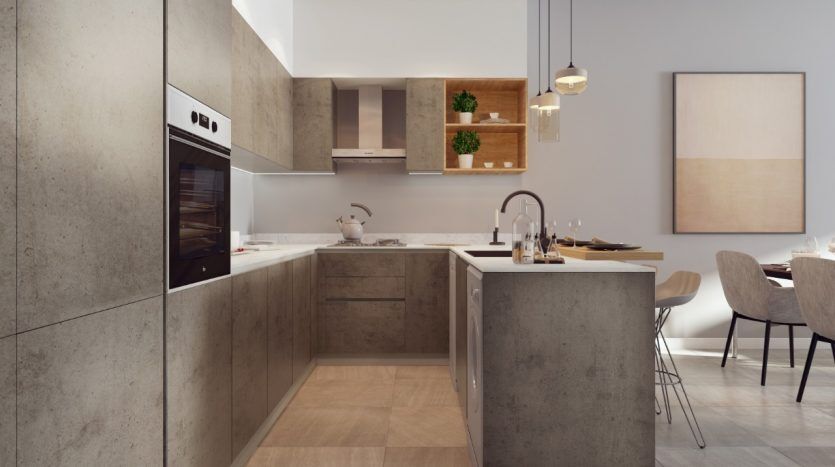 Cuisine moderne avec comptoirs en béton élégants, appareils électroménagers Panthéon Elysée intégrés et parquet. Coin repas avec table et chaises visibles en arrière-plan. La lumière naturelle illumine l'espace.
