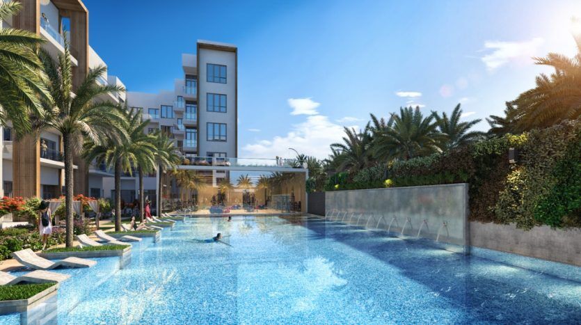 Piscine luxueuse de l'hôtel entourée de palmiers du Panthéon Elysée sous un ciel bleu clair, avec des gens nageant et se prélassant, avec des bâtiments modernes en arrière-plan.