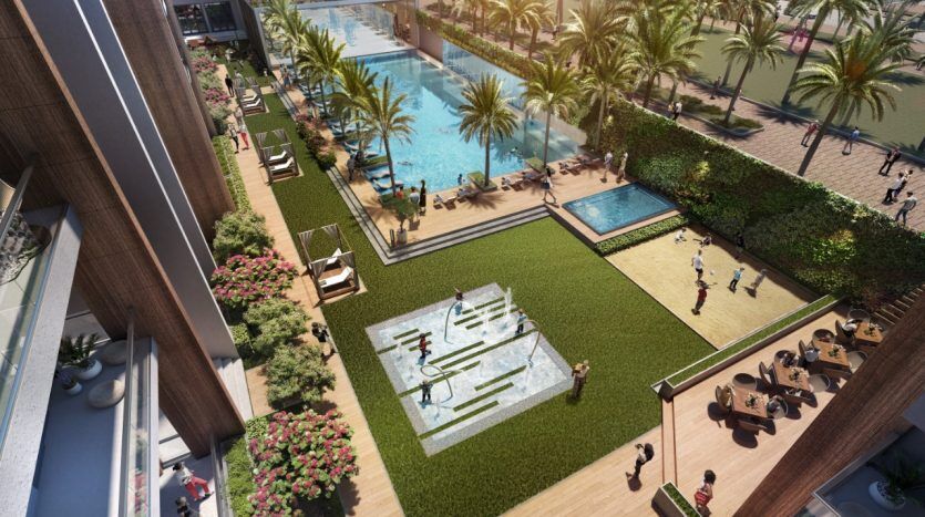 Vue aérienne d'un espace de loisirs extérieur animé comprenant une piscine, un terrain de volley-ball et une terrasse pour bronzer, entouré de palmiers luxuriants et des bâtiments modernes du Panthéon Elysée.