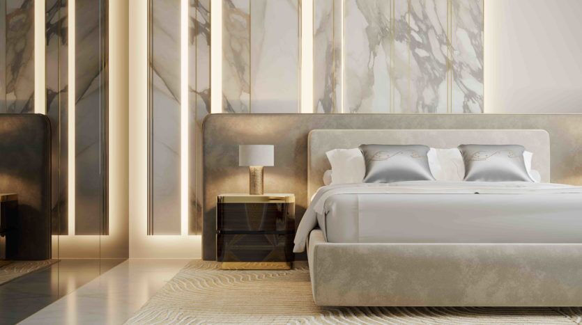 Une chambre luxueuse avec un grand lit recouvert de draps blancs, flanqué de tables de nuit et de lampes, sur fond de murs en marbre et de panneaux lumineux verticaux à l'Elie Saab Ema