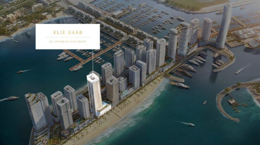 Vue aérienne d'un développement urbain côtier intitulé "Elie Saab at Emaar Beachfront" comprenant de nombreux immeubles de grande hauteur et marinas, entourés d'eau.