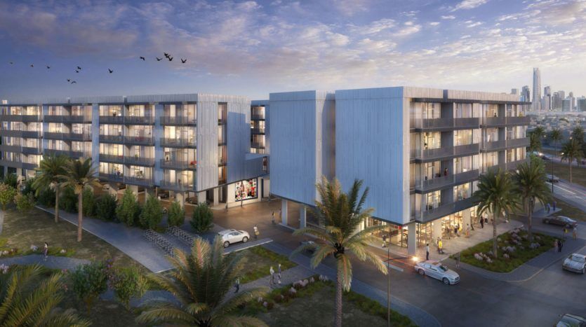 Un rendu architectural d'un complexe résidentiel moderne composé de deux bâtiments à plusieurs étages, dotés de balcons et de grandes fenêtres, situé dans le quartier paysager des Q Gardens de Dubaï au coucher du soleil.