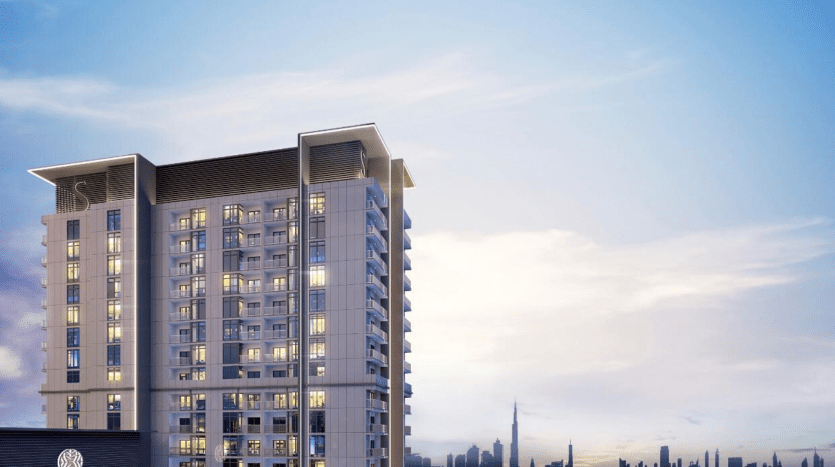 Un immeuble moderne de grande hauteur à Creek Vistas Dubai illuminé au crépuscule avec un horizon de la ville en arrière-plan sous un ciel bleu doux.