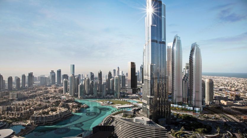 Une vue panoramique sur l'horizon de l'Address Residences Dubai Opera avec des gratte-ciel imposants, certains réfléchissant la lumière du soleil, avec des zones résidentielles urbaines au premier plan et un ciel bleu clair.
