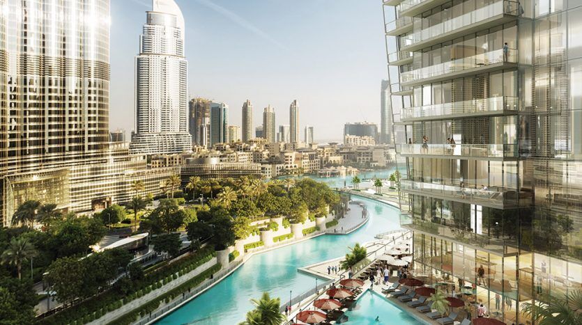 Un horizon urbain animé avec des gratte-ciel modernes surplombant une luxueuse piscine de style complexe hôtelier à Address Residences Dubai Opera, parsemée de chaises longues et entourée d'une verdure luxuriante.