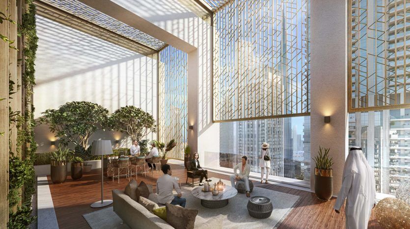 Un salon moderne et spacieux doté de baies vitrées au Burj Crown, baigné de lumière naturelle. Les gens socialisent au milieu de plantes vertes luxuriantes, de coins salons confortables et de détails architecturaux géométriques et élégants.