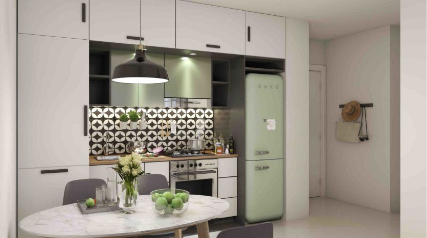 Cuisine moderne avec armoires vert menthe, réfrigérateur de style rétro, dosseret géométrique et table ronde en marbre avec chaises au Collective 2.0, Dubai Hills. Deux suspensions planent au-dessus.