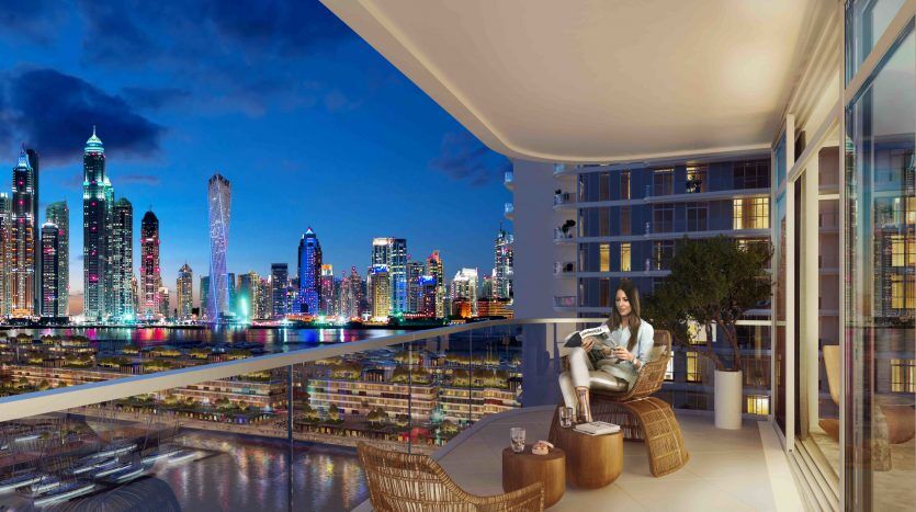 Une femme se détendant sur un balcon avec une vue panoramique sur la marina et les toits de la ville bien éclairés au crépuscule. Elle lit un livre, entourée de meubles modernes en osier.