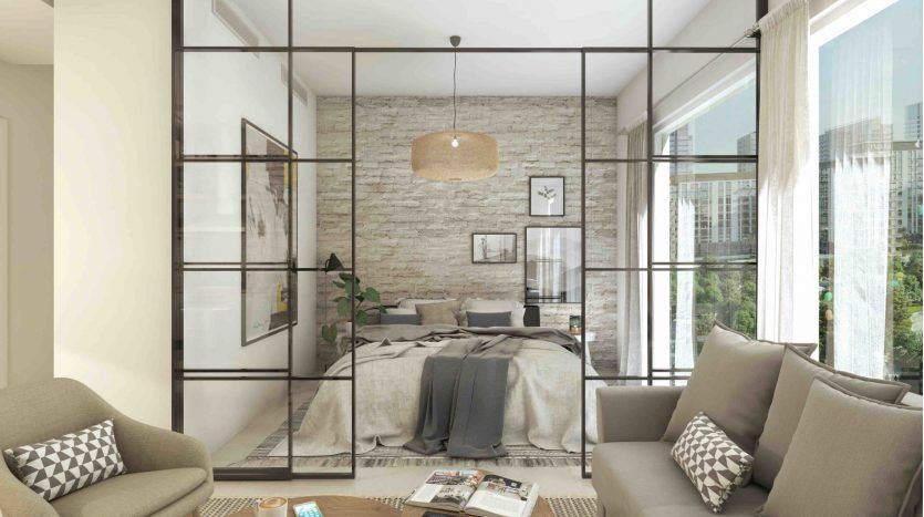 Une chambre moderne avec des murs en verre dans le Collective 2.0 Dubai Hills, comprenant un grand lit, des tons neutres et un mur d'accent en pierre rustique. La lumière naturelle pénètre à travers de grandes fenêtres avec une ville