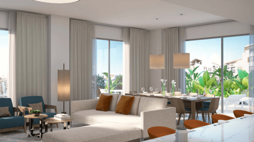Un salon et salle à manger moderne et décloisonné avec de grandes fenêtres offrant beaucoup de lumière naturelle et une vue sur La Voile Port de La Mer. La chambre est élégamment décorée avec des tons neutres et un mobilier contemporain