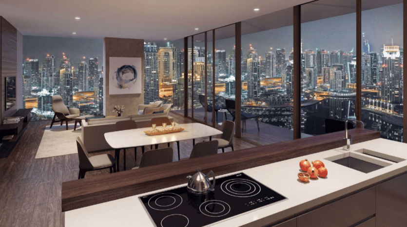 Intérieur de cuisine moderne au design élégant au Jumeirah Living Marina Gate, surplombant un paysage urbain animé la nuit à travers des fenêtres panoramiques. La chambre dispose d'un îlot de cuisine, d'un mobilier contemporain et d'un éclairage tamisé