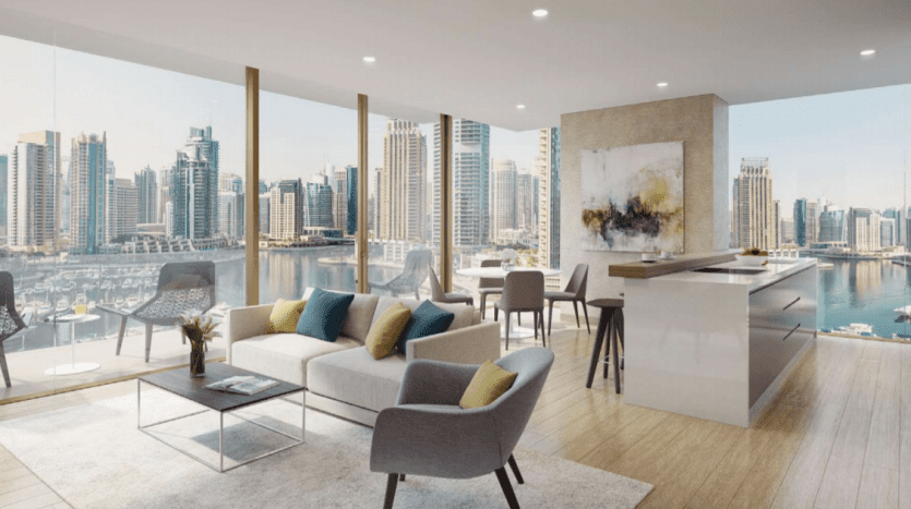 Salon moderne du Jumeirah Living Marina Gate avec une grande fenêtre donnant sur les toits de la ville et la marina. L'intérieur comprend un canapé, des chaises et un coin bar cuisine, créant un espace lumineux.