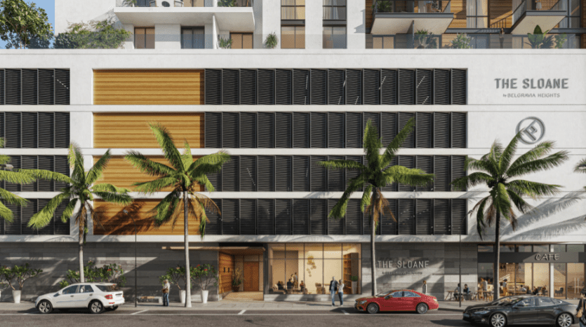 Façade d'hôtel urbain moderne à Sloane JVC présentant une combinaison d'éléments en verre, en bois et en béton, avec des palmiers bordant la rue et des voitures garées devant.