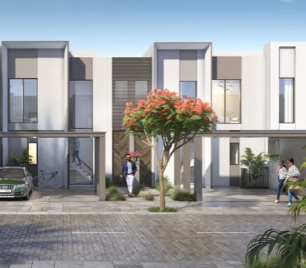 Développement résidentiel moderne dans The Valley, Dubaï, comprenant une rangée de maisons de ville élégantes avec de grandes fenêtres et des toits plats. Des gens, dont une femme qui marche et deux hommes qui discutent, animent la scène.