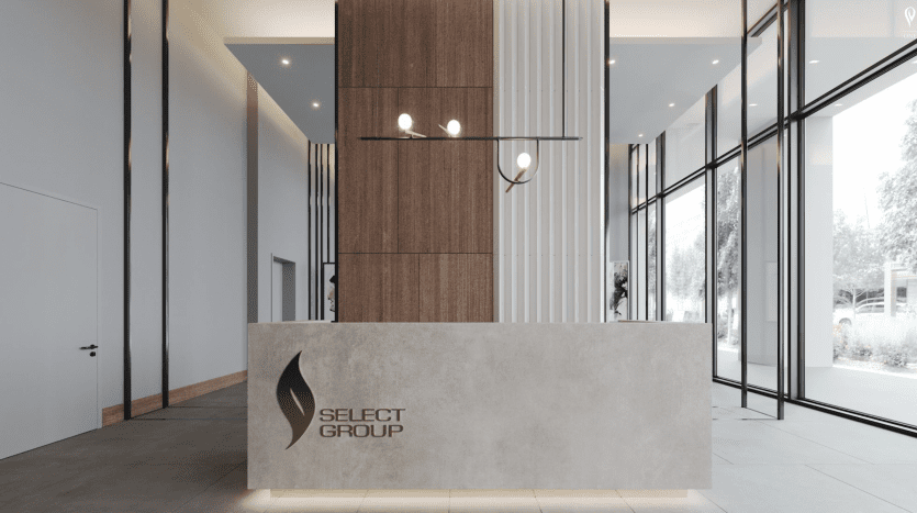 Hall de bureau moderne avec un élégant comptoir de réception rectangulaire portant le logo "Peninsula Select Group". La zone présente des panneaux de bois verticaux, des murs de verre et des suspensions minimalistes.