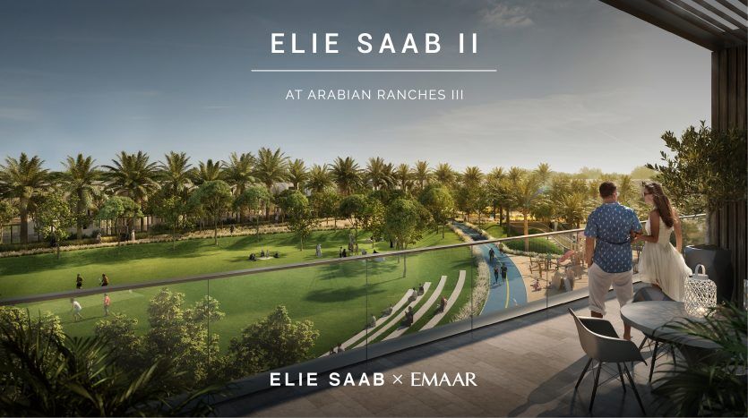 Image promotionnelle d'Elie Saab à Arabian Ranches III, montrant un couple sur un balcon donnant sur un quartier résidentiel luxueux avec une verdure luxuriante, une piscine et des sentiers pédestres.