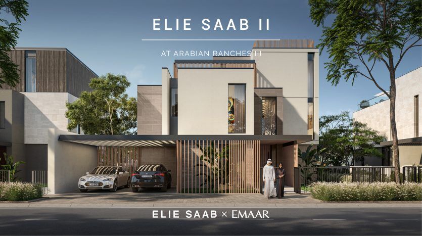 Un immeuble résidentiel élégant et moderne portant le label « Elie Saab at Arabian Ranches III », comprenant une allée avec des voitures garées et un homme debout près de l'entrée.