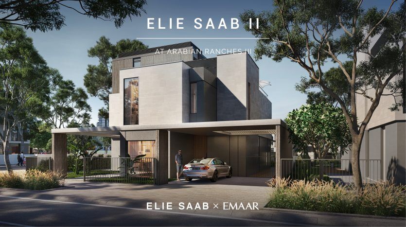 Une maison de luxe moderne conçue par Elie Saab à Arabian Ranches, présentant des éléments architecturaux élégants, avec une voiture garée sous une entrée couverte et des arbres entourant les lieux.