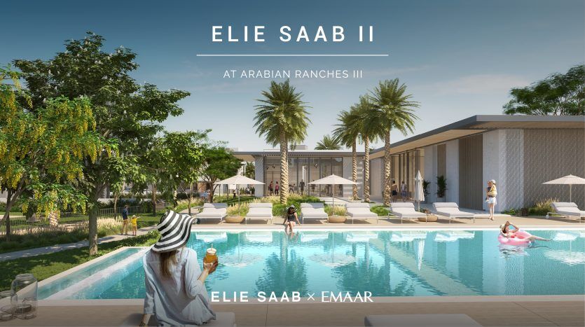 Scène de luxe au bord de la piscine à « Elie Saab at Arabian Ranches III » avec une femme élégante coiffée d'un chapeau tenant une glace, face à une piscine tranquille flanquée d'une verdure luxuriante et