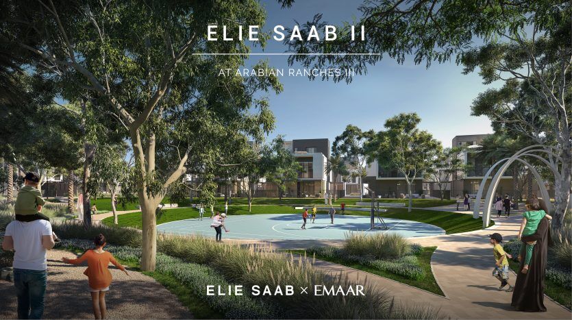 Un parc communautaire animé avec des familles et des enfants qui jouent, des arbres verts luxuriants entourent les maisons modernes et une aire de jeux centrale sous un ciel dégagé. Le texte indique « Elie Saab II à Arabian Ranches, El