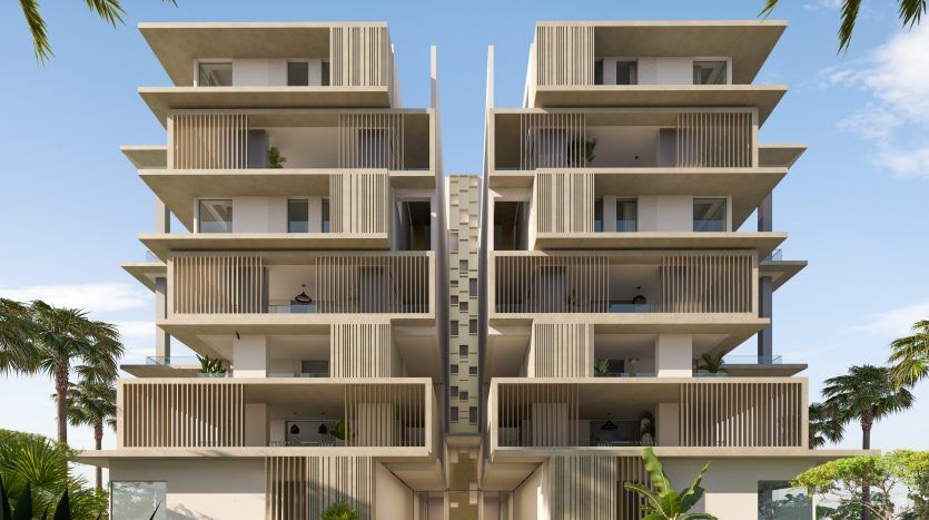 Immeuble d'appartements moderne de six étages au design symétrique, doté de balcons extérieurs à lattes de bois, de grands palmiers et d'une passerelle centrale, situé dans un cadre tropical idéal pour investir dans l'immobilier de Dubaï.