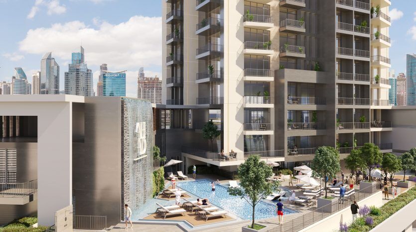 Rendu d'un complexe d'appartements moderne à Dubaï comprenant une grande piscine extérieure, des bains de soleil et de grands immeubles en arrière-plan sous un ciel clair.