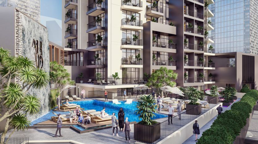 Immeuble d'appartements moderne à Dubaï avec une piscine luxueuse entourée d'une verdure luxuriante et des résidents se prélassant, situé dans un cadre urbain.
