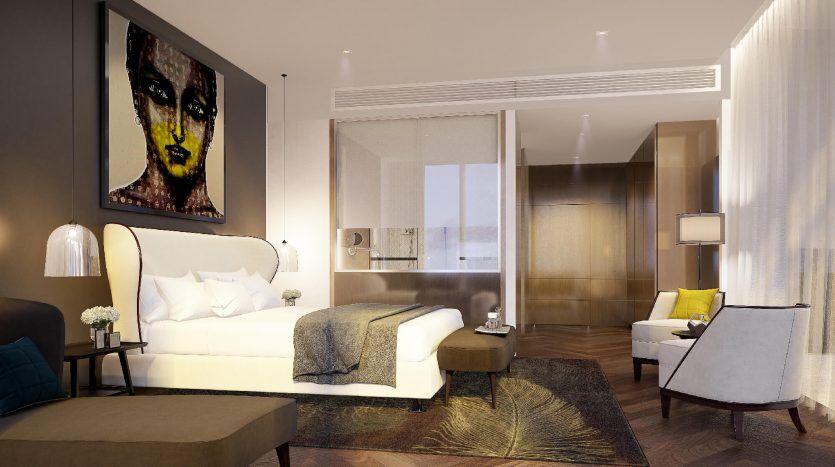 Une chambre d'hôtel moderne à Dubaï comprenant un grand lit avec une tête de lit blanche, des meubles contemporains et une œuvre d'art abstraite saisissante au-dessus d'une table d'appoint. Un éclairage doux et une décoration élégante créent une ambiance chaleureuse
