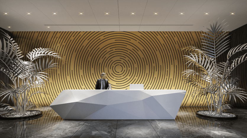 Un hall d'entrée d'hôtel moderne doté d'un comptoir de réception géométrique saisissant avec un homme debout derrière lui, flanqué de grands palmiers métalliques, sur un fond aux motifs circulaires audacieux à Dubaï.