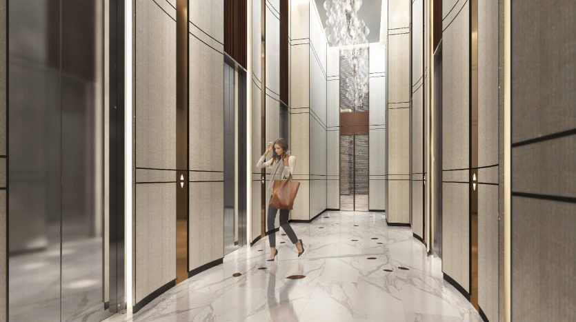 Une femme en costume d'affaires se promène dans le hall d'une villa luxueuse et moderne à Dubaï avec de hauts plafonds, des sols en marbre et des lustres élégants. Elle porte une mallette et est en mouvement, soulignant