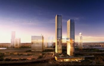 Une vue panoramique d'un paysage urbain moderne au crépuscule avec de grands gratte-ciel éclairés par des lumières chaudes, avec une rivière en arrière-plan et une route animée au premier plan. Cette scène met en évidence les opportunités lucratives