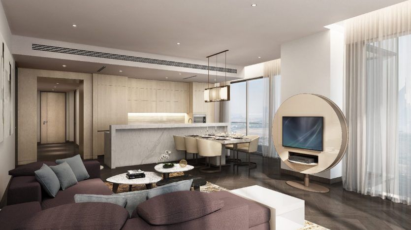 Un intérieur d'appartement moderne avec un salon décloisonné comprenant un canapé sectionnel bleu foncé, une table basse ronde blanche, une chaise blanche sphérique unique avec un meuble TV intégré, un coin repas adjacent et un