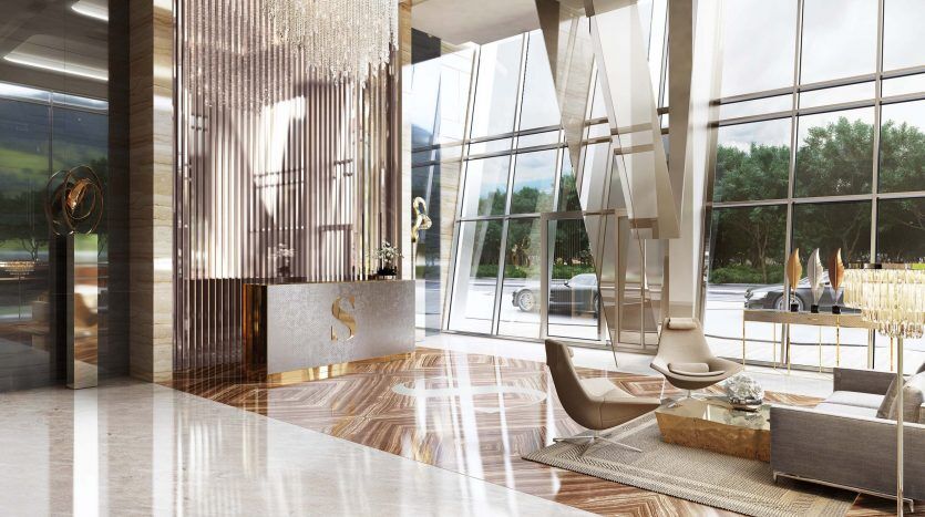 Hall d'entrée luxueux avec de grandes fenêtres en verre, de hauts plafonds avec un lustre moderne, un mobilier élégant et des sols en marbre au Sterling Dubai, surplombant un paysage verdoyant.