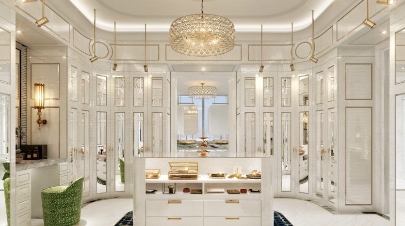 Intérieur de salle de bains de yacht luxueux avec un élégant décor doré et blanc, des panneaux de miroir, un lustre et une vue sur l'océan à travers de grandes fenêtres. Un espace vanité avec divers produits de beauté est mis en évidence, rappelant les hautes