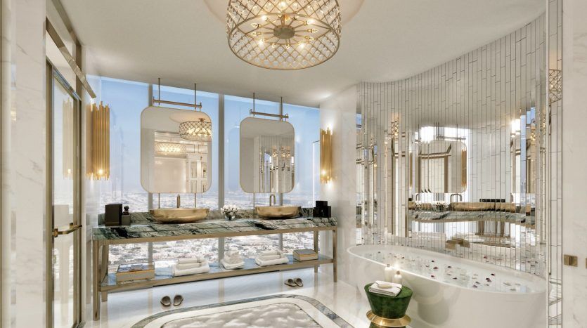 Salle de bains luxueuse avec sols en marbre, bain à remous autoportant, miroirs ornés aux accents dorés, colonnes blanches et grande fenêtre ensoleillée offrant une atmosphère lumineuse et spacieuse parfaite pour